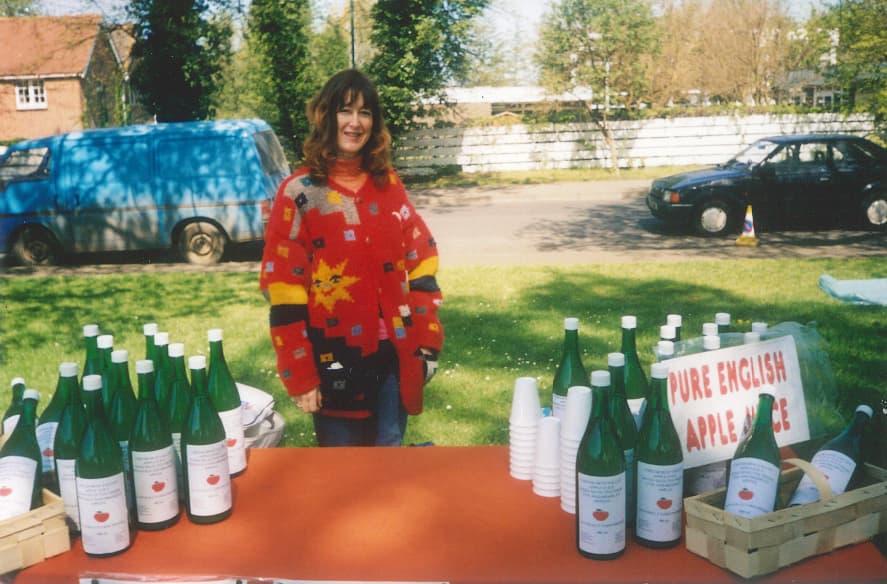 Chegworth Valley apple juice stall with bottled pure English apple juice displayed outdoors at a local market setting in Kent.