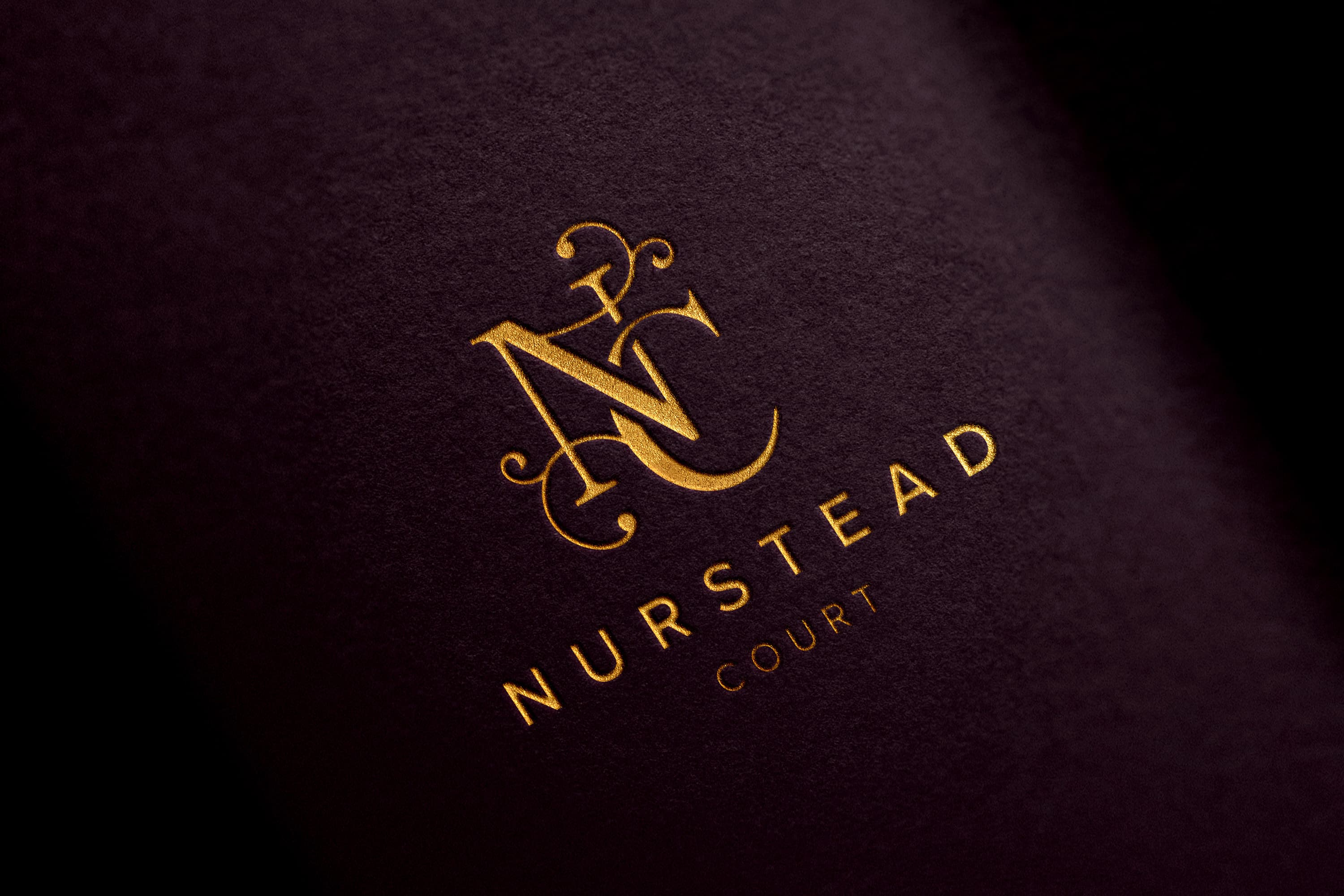 Nurstead Court gold foil logo embossed on luxury fabric showcasing premium brand identity and high-end hospitality branding design