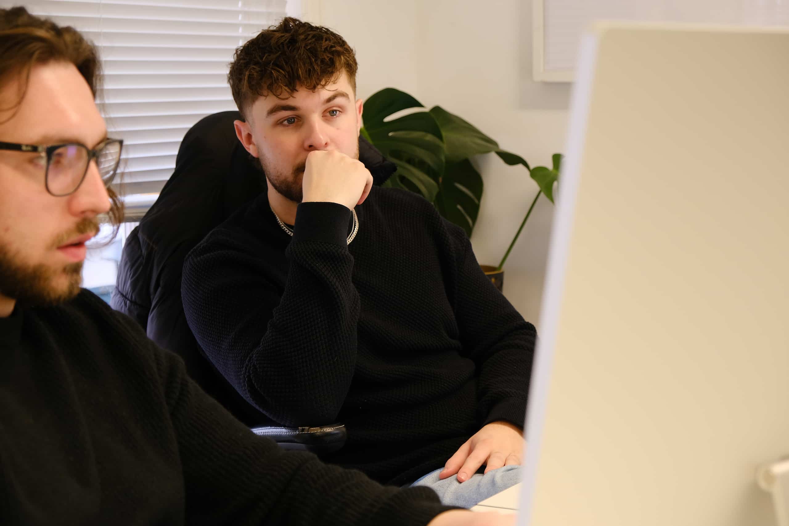 Spike and Kian Collaborating at a Computer Spike and Kian working together at a desktop computer in a modern office workspace.
